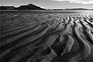 Symmetrical lines of beach sand exposed during low tide at Eagle Beach.